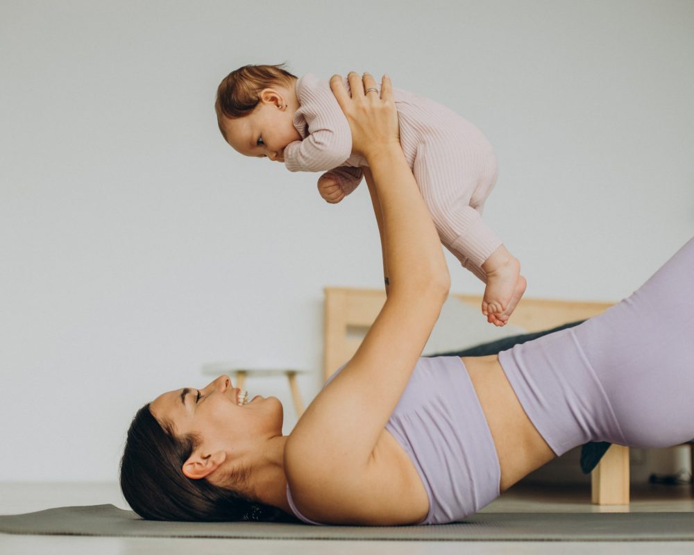 Mother with her baby daughter practice yoga at home